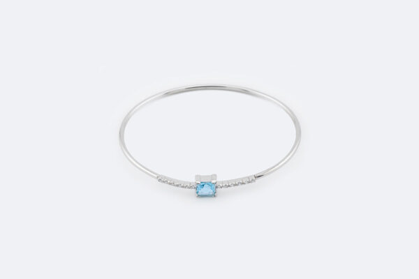 Bracciale rigido in oro bianco con topazio azzurro e zirconi